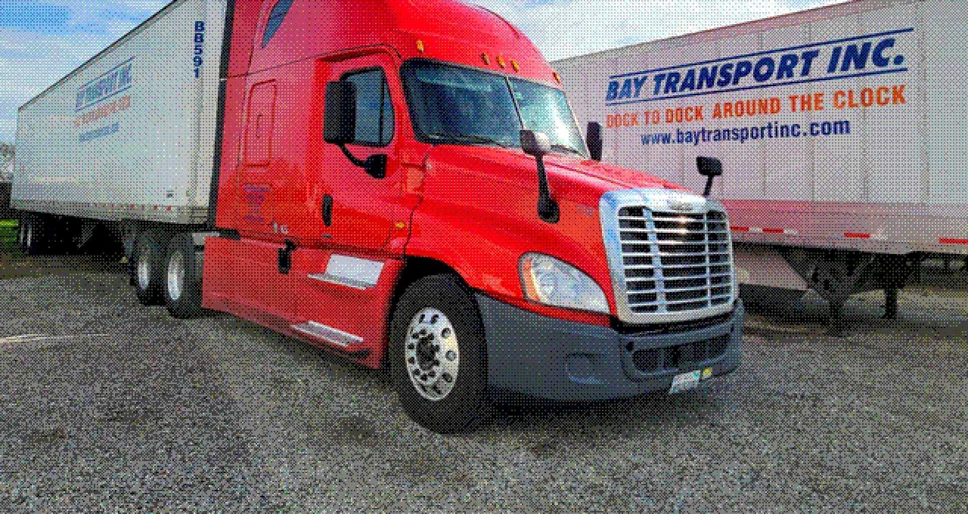 A red Bay Transport tractor beside a trailer lettered Bay Transport Inc., Dock to dock around the clock.